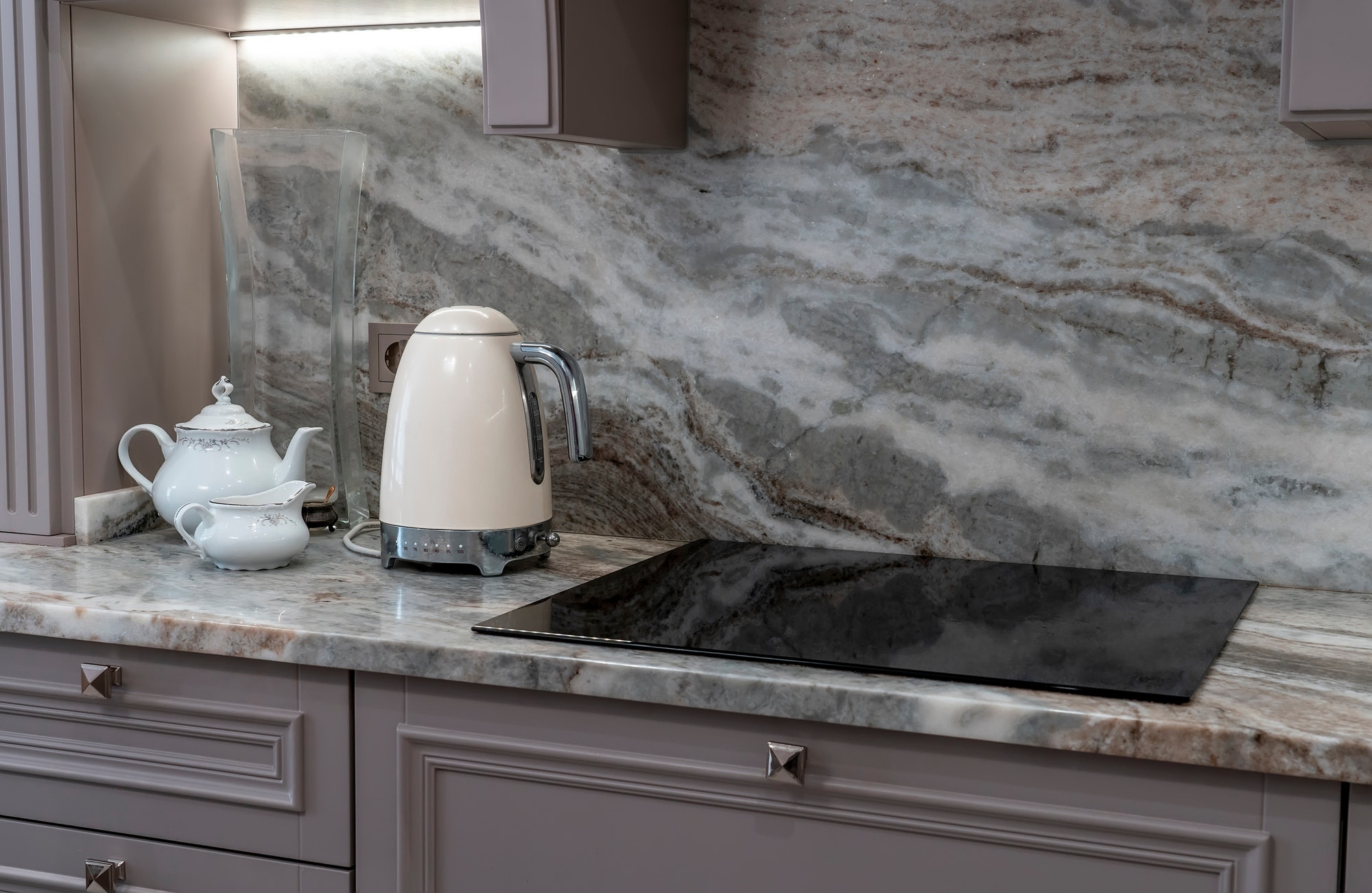 beautiful closeup of custom designed kitchen, with marble looking quartz countertop and backsplash.