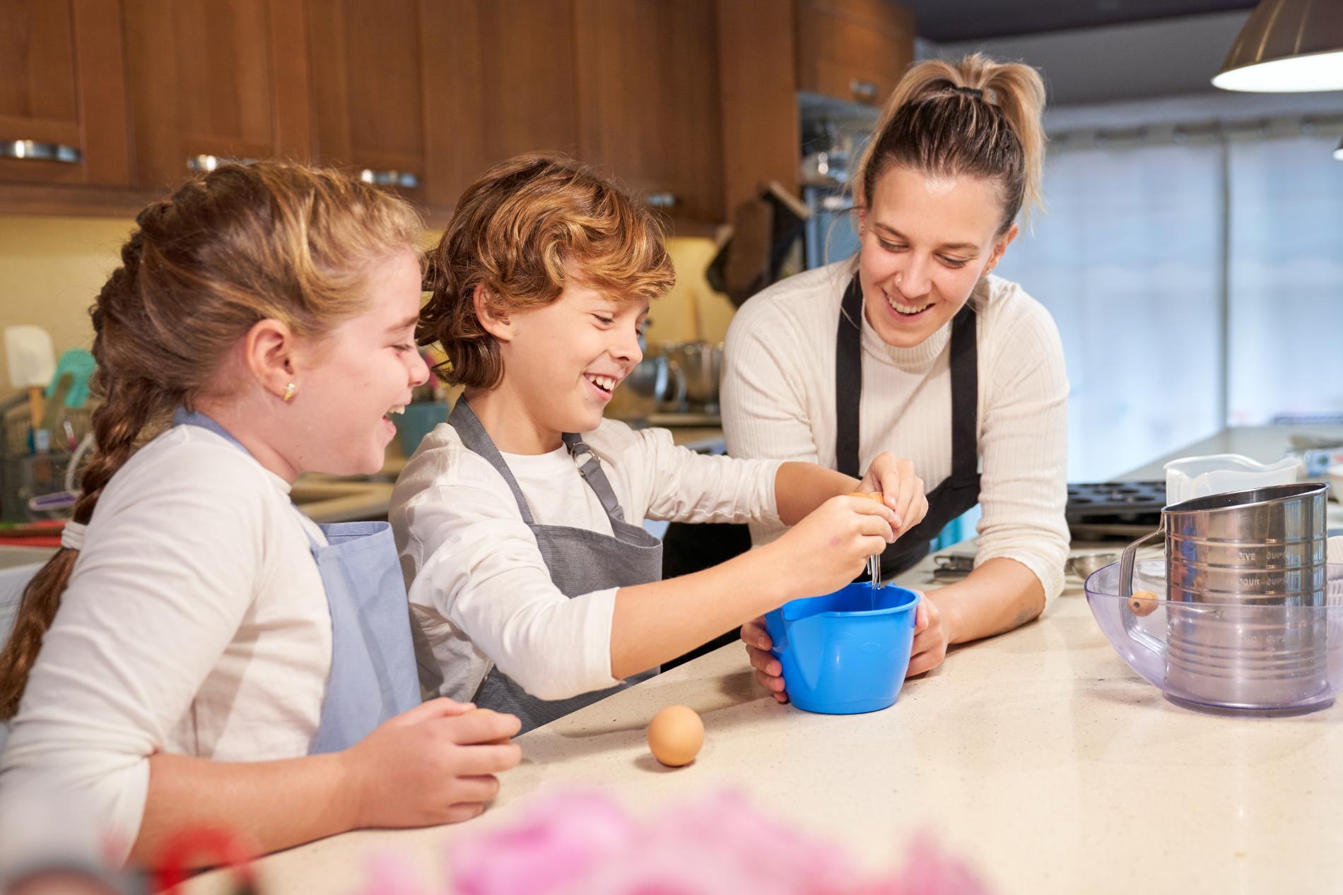 laughing-children-cooking-batter-with-mother-in-ki-2023-11-27-05-20-19-utc.jpg